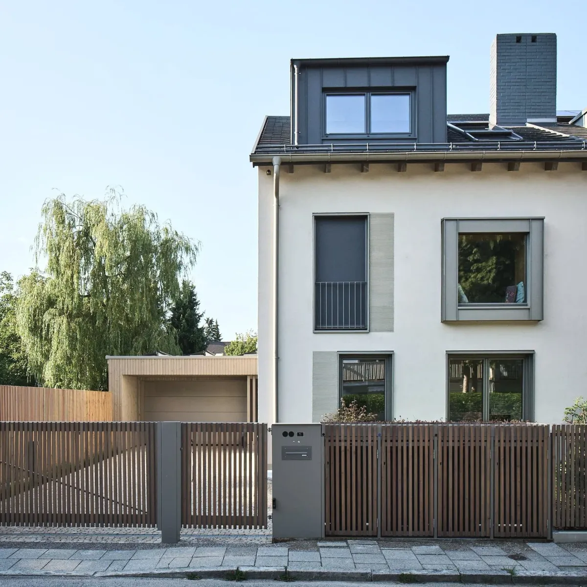 Straßenansicht mit Lamellenzaun und Garage