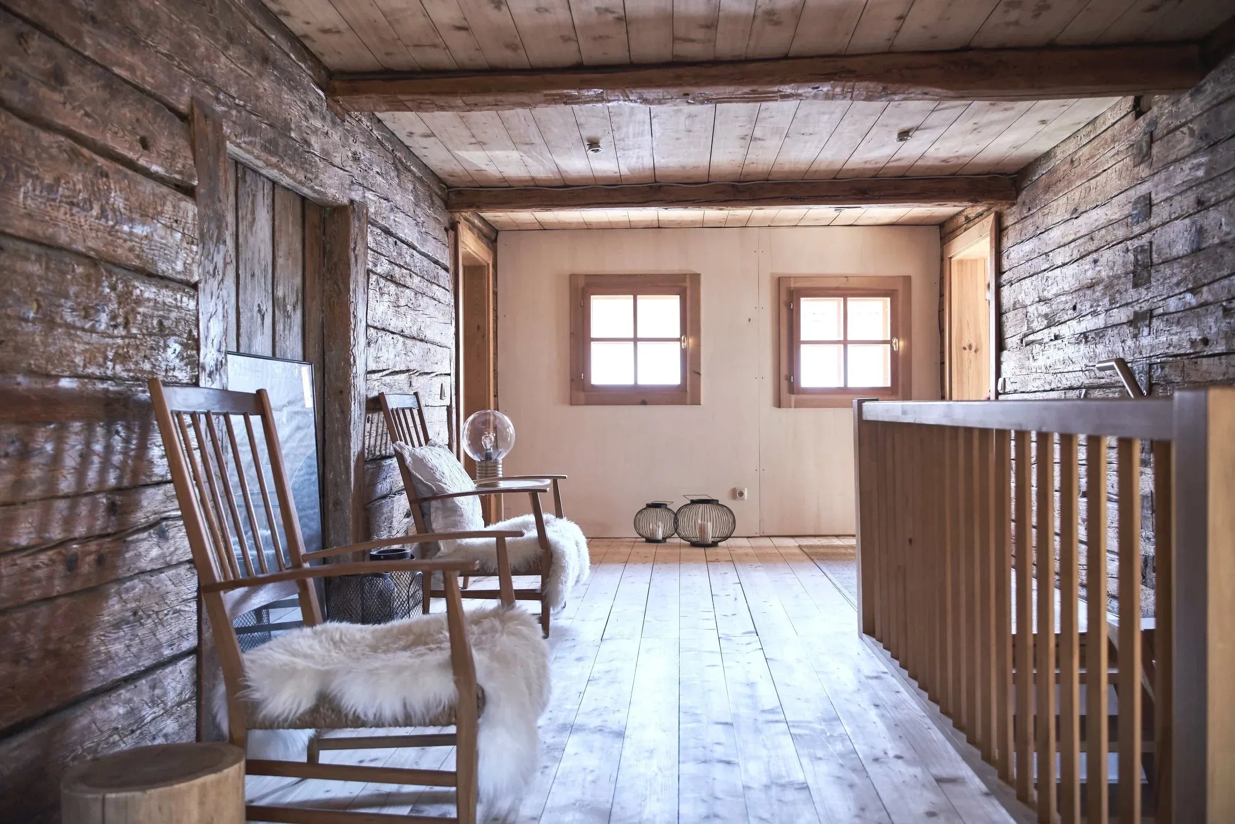 Galerie mit historischem Blockholz, Schaukelstühlen und Schaffellen