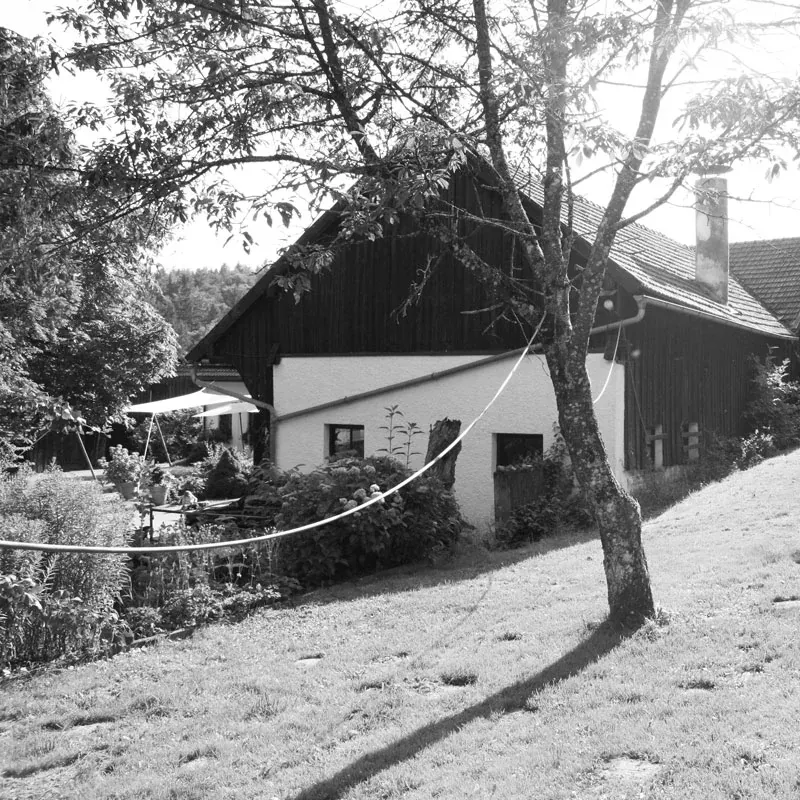 Historische Schwarz-Weiß-Aufnahme des Bauernhofs mit Scheune